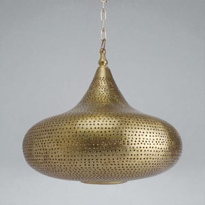 May include: A brass-colored pendant light fixture with a wide, rounded body and a tapered top. The metal surface is covered in a dense, uniform pattern of small, circular perforations. It hangs from a thin metal chain attached to the top finial.
