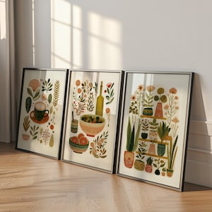 Puede incluir: Tres impresiones artísticas enmarcadas con ilustraciones botánicas y de alimentos. Una impresión muestra una taza de café, otra representa aceitunas y naranjas, y la tercera muestra plantas en macetas en estantes. Las impresiones tienen marcos negros.