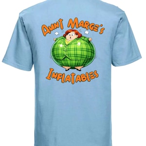 Puede incluir: Camiseta azul claro con una ilustración de dibujos animados de una mujer con un traje a cuadros verdes, inflada como un globo. El texto "Aunt Marge's Inflatables" está escrito encima y debajo de la ilustración en naranja.