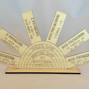 May include: A wooden, circular, rainbow-shaped plaque with the words "I Promise", "God Promises", and "My Baptismal Covenants" inscribed on it. The plaque is divided into sections, each with a different promise or covenant.