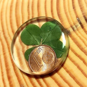 Pocket luck, two is better than one. &quot;Real four-leaf clover and lucky cent.&quot; Lucky charm to go. In epoxy resin.
