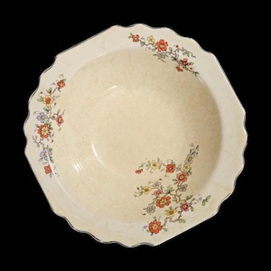 May include: Cream-colored, octagonal serving bowl with a scalloped edge and floral design. The bowl features a delicate pattern of red, yellow, and blue flowers with green leaves. The rim has a silver trim.