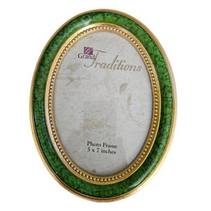 May include: An oval photo frame featuring a green crackle-patterned border with a gold-toned beaded inner rim. The insert displays the text Grand Traditions Photo Frame 5 x 7 inches. The frame has a smooth, polished finish and a gold-toned outer edge.