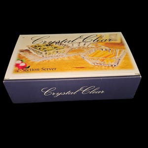 May include: A boxed crystal clear 2-section server. The box is navy blue with the words "Crystal Clear" in cursive. The top of the box shows the server with olives and orange food items. The words "2-Section Server" are also visible.