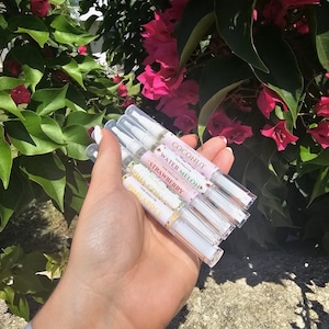 May include: Five clear lip gloss tubes with colorful labels. The labels feature fruit designs and names like "Coconut", "Water Melon", "Strawberry", "Pineapple", and "Mango".