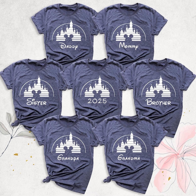 May include: Seven heather blue t-shirts with a white silhouette of Cinderella's castle and Mickey Mouse ears. The shirts have the words "Daddy", "Mommy", "Sister", "2025", "Brother", "Grandpa", and "Grandma" printed on them.