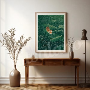 Op de afbeelding: Een ingelijste wandkunstprint met een oranje en zwarte tijger die zwemt in diepgroene, gestileerde oceaangolven. Het kunstwerk wordt getoond in een lichtgekleurde houten lijst en toont een gedetailleerde illustratie van de kop van de tijger.