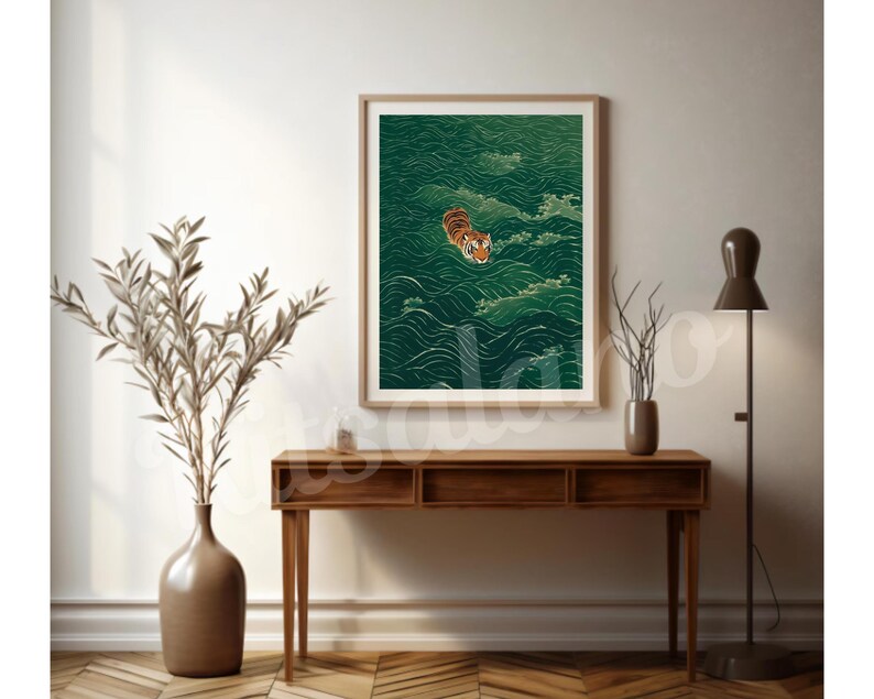 Op de afbeelding: Een ingelijste wandkunstprint met een oranje en zwarte tijger die zwemt in diepgroene, gestileerde oceaangolven. Het kunstwerk wordt getoond in een lichtgekleurde houten lijst en toont een gedetailleerde illustratie van de kop van de tijger.