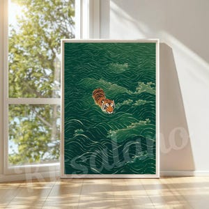 Op de afbeelding: Een rechthoekige wandkunstprint met een oranje en zwarte tijger die door diepgroene, gestileerde golven zwemt. Het kunstwerk wordt gepresenteerd in een eenvoudige witte lijst en toont een gedetailleerde illustratie van de kop en rug van de tijger.