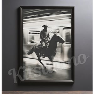May include: Black and white framed print of a cowboy riding a horse in a subway station. The image is a study in contrasts, with the cowboy and horse in sharp focus against the blurred background of a passing train.