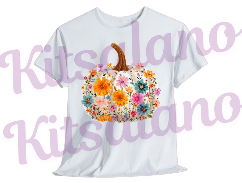May include: White t-shirt featuring a floral pumpkin design. The pumpkin is white with a brown stem and is adorned with colorful flowers in shades of orange, pink, blue, and yellow. The design is centered on the front of the shirt.