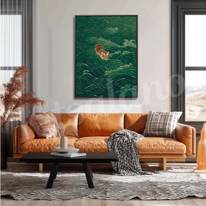 Op de afbeelding: Een rechthoekige wandkunstprint met een tijger die zwemt in donkergroen water met gestileerde golfpatronen. De tijger is oranje met zwarte strepen en bevindt zich in het midden bovenaan. Het kunstwerk is ingelijst in een zwarte lijst.