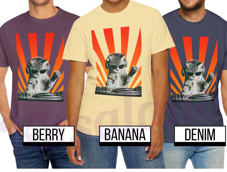 May include: T-shirts in berry, banana, and denim colors, each featuring a graphic of a cat wearing sunglasses and headphones, DJing with a turntable against a red and orange sunburst design. The shirts are displayed on models.