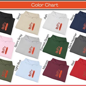 Koi Fish Hoodie color chart, featuring the Black, Ash, Sand, White, Navy, Pink, Forrest Green, Dark Heather, Sport Grey and Red. The hoodie features the Japanese cultural symbols of the Koi Fish, cherry blossoms, the Japanese sun and Kanji writing.
