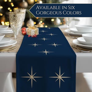 May include: A navy blue table runner with a starburst pattern in gold. The runner is set on a white tablecloth, with white plates, gold chargers, and glassware. The text "AVAILABLE IN SIX GORGEOUS COLORS" is displayed in a navy blue banner.