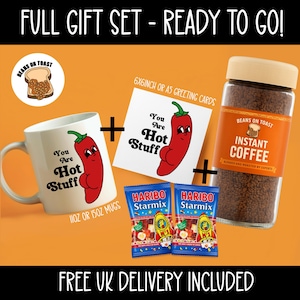 May include: A gift set featuring a white mug, greeting card, instant coffee, and two bags of Haribo Starmix candy. The mug and card have a cartoon chili pepper design with the text "You Are Hot Stuff". The coffee is in a glass jar.