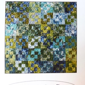 K&ouml;nnte beinhalten: Ein Quiltmuster namens "Eclipse" mit einem Patchwork-Design aus blauen, gr&uuml;nen und gelben Stoffquadraten. Das Muster stammt von Designs by jb.