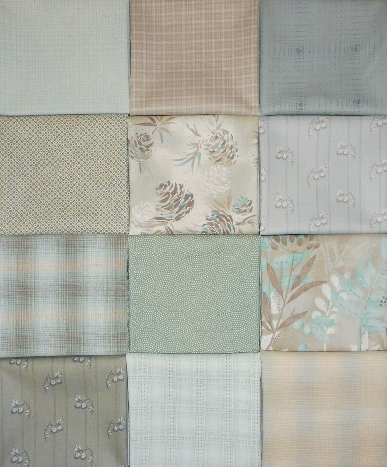K&ouml;nnte beinhalten: Eine Sammlung von 12 Stoffquadraten in verschiedenen Gr&uuml;nt&ouml;nen, Braun- und Blaut&ouml;nen. Die Stoffe zeigen verschiedene Muster, darunter Karos, Blumen und geometrische Designs.