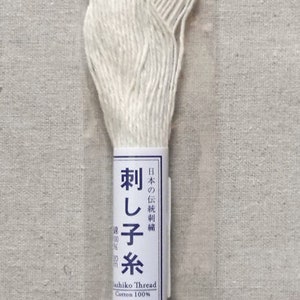 May include: White cotton embroidery floss in a plastic package with Japanese text that reads "Olympus Sashiko Thread Cotton 100%" and "刺し子糸" which translates to "Sashiko Thread".