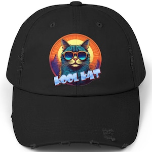 May include: Black distressed baseball cap featuring a graphic of a cat wearing sunglasses and the text "Kool Kat" in a retro font.
