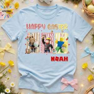 May include: Light blue t-shirt with the words "HAPPY EASTER" in yellow and red. The shirt features three cartoon characters with Easter eggs and a basket. The name "NOAH" is printed in red below the characters.