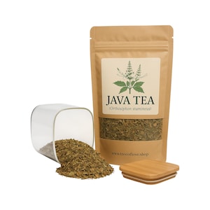 Könnte beinhalten: Eine braune Papiertüte mit Java-Tee (Orthosiphon stamineus) mit einem transparenten Glasbehälter und einem Bambusdeckel. Die Teeblätter sind in der Verpackung und aus dem Behälter zu sehen. Das Etikett trägt die Aufschrift "JAVA TEA" mit einer botanischen Illustration.