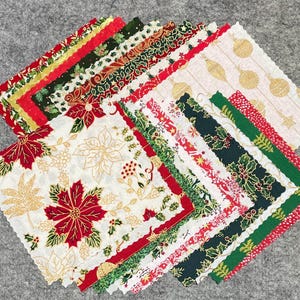 May include: A stack of 20 fabric squares with a Christmas theme. The squares feature various patterns including poinsettias, holly, baubles, and snowflakes. The fabric is a mix of red, green, white, and gold.