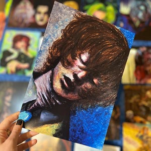 Peut inclure: Un gros plan sur une peinture d'une personne aux cheveux bruns sur un fond bleu. Les yeux de la personne sont fermés et sa bouche est légèrement ouverte. La peinture est réalisée dans un style réaliste avec beaucoup de détails.