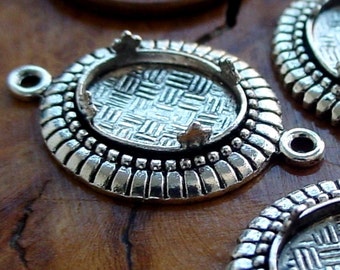 May include: Silver-toned metal pendant with a decorative oval bezel and a textured design. The pendant has a loop for attaching a chain or cord.