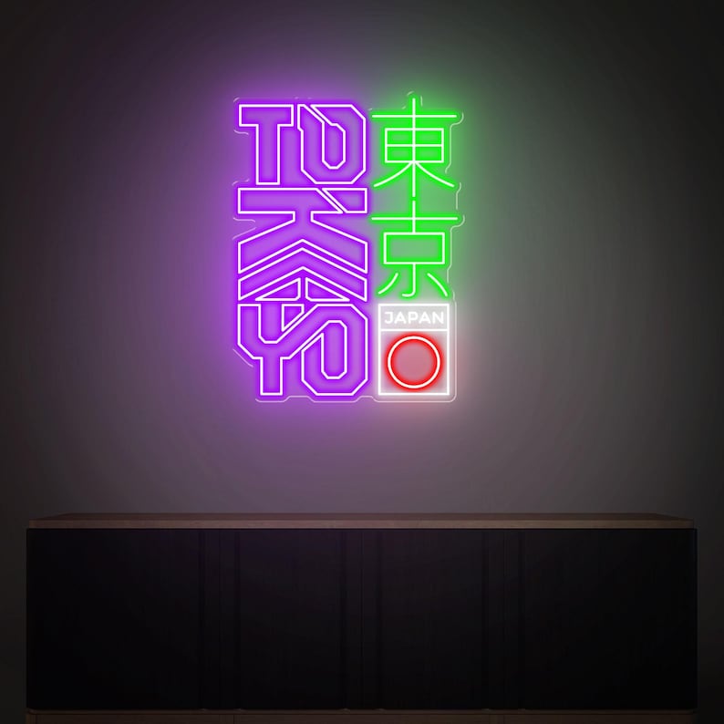 May include: Neon sign with the word "TOKYO" in purple and green. The Japanese characters are illuminated with neon lights. The sign also includes a white box with a red circle and the word "JAPAN".