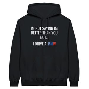 May include: Black hooded sweatshirt with white text that reads "I'm not saying I'm better than you but... I drive a BMW". The BMW logo is in blue and red.