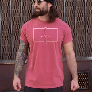 Könnte beinhalten: Bordeauxfarbenes T-Shirt mit weißem Diagramm eines Stromkreises. Das Diagramm enthält Symbole für Widerstand, Spannung und Strom. Das Shirt hat kurze Ärmel und eine lockere Passform.