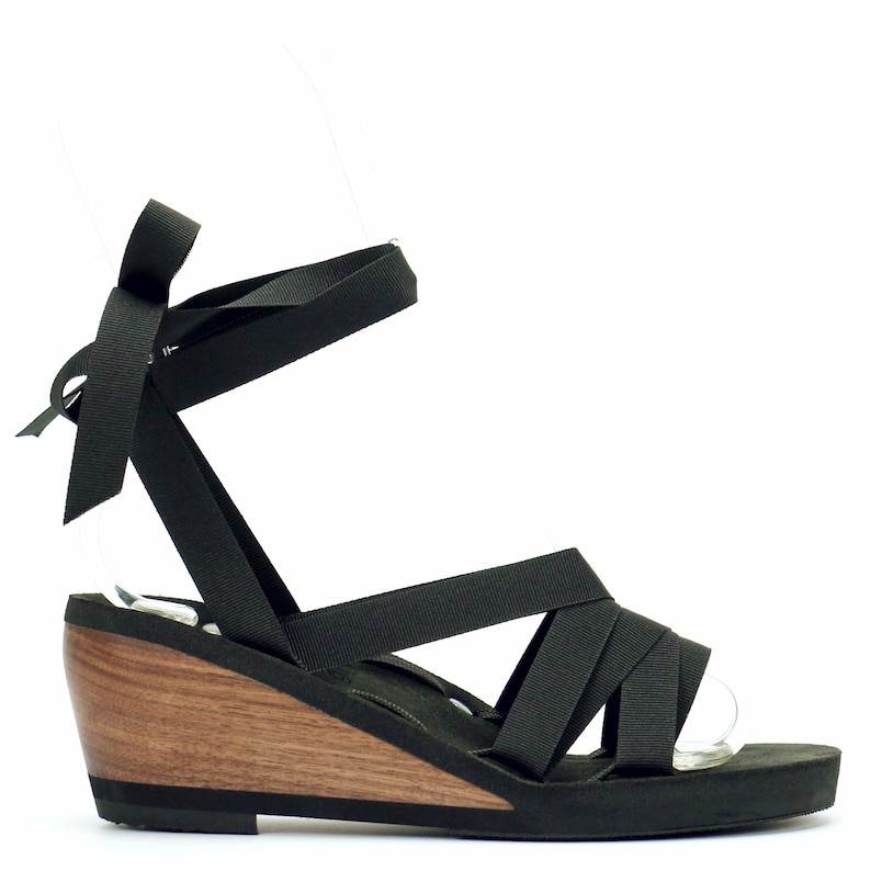 Mid wedge slide sandal laced with 5/8" black ribbon. Wood heel is ergonomically carved using sustainably sourced walnut wood. Style shown uses a slide style loop patten with 4 side loops for lacing interchangeable ribbons.