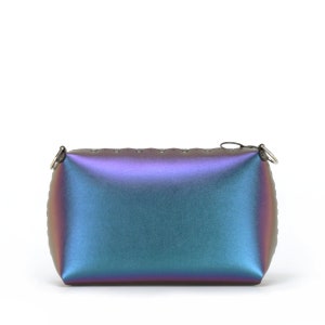May include: Iridescent rectangular clutch with a zipper closure and small metal rings on the corners. The bag transitions from purple to teal and blue. The top edge has small, evenly spaced holes.