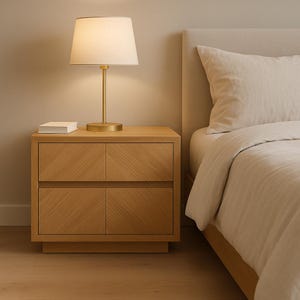以下が含まれることがあります： 白いベッドリネンを敷いたベッドの横に、引き出しが2つ付いた木製のナイトスタンドと、白いシェードのついた金色のテーブルランプが置かれています。