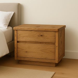 Op de afbeelding: Een houten nachtkastje met twee laden en een onderplank. Het nachtkastje is gemaakt van lichtbruin hout met een natuurlijke afwerking.