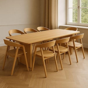 Könnte beinhalten: Ein hellfarbener Esstisch aus Holz mit acht passenden Stühlen. Der Tisch hat eine rechteckige Platte und eine zentrale Stütze. Die Stühle haben gebogene Rückenlehnen und einfache, abgewinkelte Beine. Der Raum hat eine neutrale Farbpalette und ein Fenster.