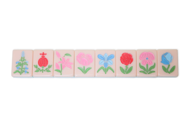 May include: Eight pink mahjong tiles with different flower designs. The flowers are in shades of pink, red, blue, and green.