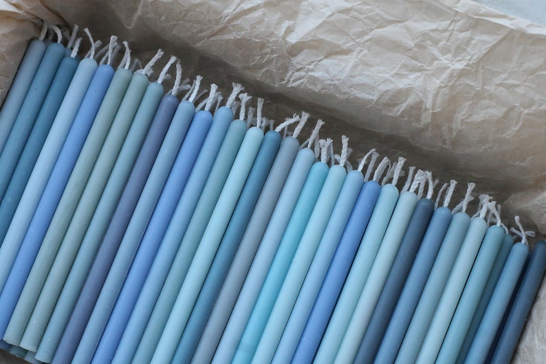 Peut inclure: Un assortiment de bougies coniques bleues de diff&eacute;rentes nuances, du bleu clair au bleu fonc&eacute;, dispos&eacute;es dans une bo&icirc;te. Chaque bougie a une m&egrave;che blanche. Ces bougies sont un article d&eacute;coratif, pour la d&eacute;coration int&eacute;rieure ou les &eacute;v&eacute;nements.