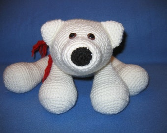 Può includere: Orso polare di peluche bianco lavorato a uncinetto con occhi neri e naso nero. L'orso è sdraiato sulla pancia con le zampe distese.