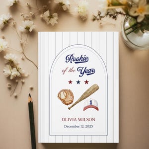 May include: A baseball-themed Rookie of the Year award certificate. The design includes a baseball glove, bat, and cap, with the text "Rookie of the Year" and the name Olivia Wilson, dated December 12, 2025. The background is white with blue pinstripes.