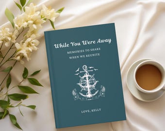 May include: A teal-colored book titled "While You Were Away" with white text and an anchor design. The book includes the text "Memories to Share When We Reunite" and "Love, Kelly". A cup of coffee and flowers are in the background.