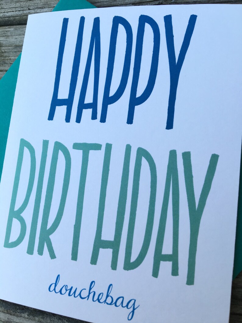 May include: A white card with blue and green lettering that says "Happy Birthday douchebag".