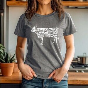 May include: A heather gray t-shirt with a white graphic of a cow with different cuts of meat labeled. The labels include "Chuck", "Rib", "Brisket", "Plate", "Flank", and "Short loin".