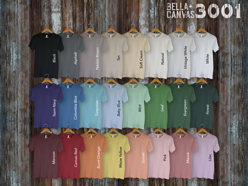 May include: A display of 30 Bella + Canvas 3001 t-shirts in various colors, including black, white, navy, red, orange, yellow, green, blue, and brown. The shirts are arranged in rows on a wooden background.