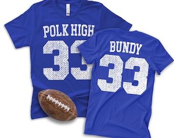 May include: Two royal blue short-sleeve t-shirts featuring white screen-printed graphics. One shirt displays POLK HIGH and the number 33, while the other shows BUNDY and the number 33. A brown leather American football is positioned in the foreground.