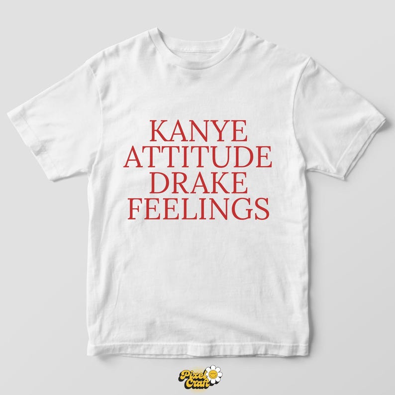 Puede incluir: Camiseta blanca con las palabras "KANYE ATTITUDE DRAKE FEELINGS" impresas en rojo. La camiseta tiene mangas cortas y cuello redondo. El texto est&aacute; centrado en la parte delantera de la camiseta.