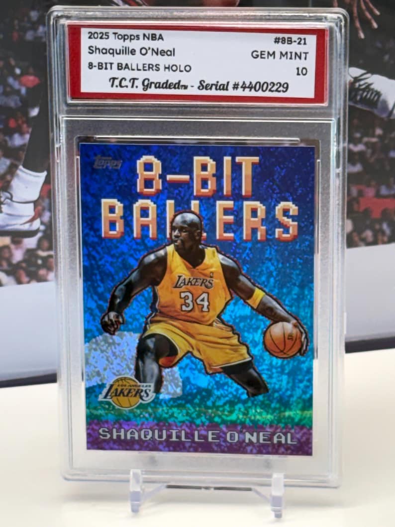 May include: A graded 2025 Topps NBA trading card featuring Shaquille O'Neal in a Los Angeles Lakers uniform. The card is part of the 8-Bit Ballers series and is graded GEM MINT 10. The card is encased in a protective holder.