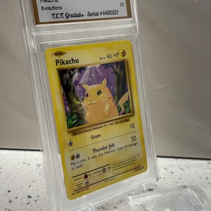 May include: A graded 2016 Pokémon Pikachu Evolutions card, serial #4400321, in a protective case. The card features a yellow Pikachu character with the text "Pikachu" and "60 HP". The card is graded GEM MINT 10.
