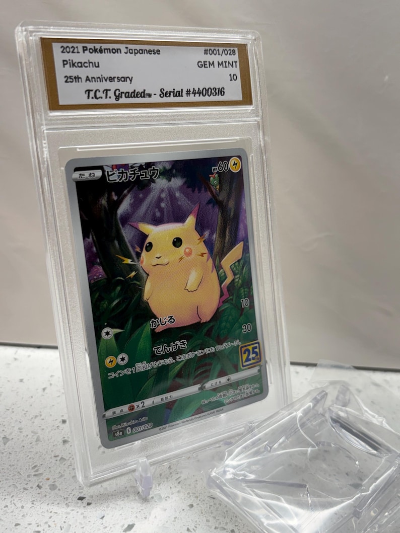 Puede incluir: Carta Pok&eacute;mon de Pikachu de la edici&oacute;n 25 aniversario, calificada GEM MINT 10 por T.C.T. La carta, con texto japon&eacute;s, est&aacute; protegida en un estuche. N&uacute;mero de serie #4400316.